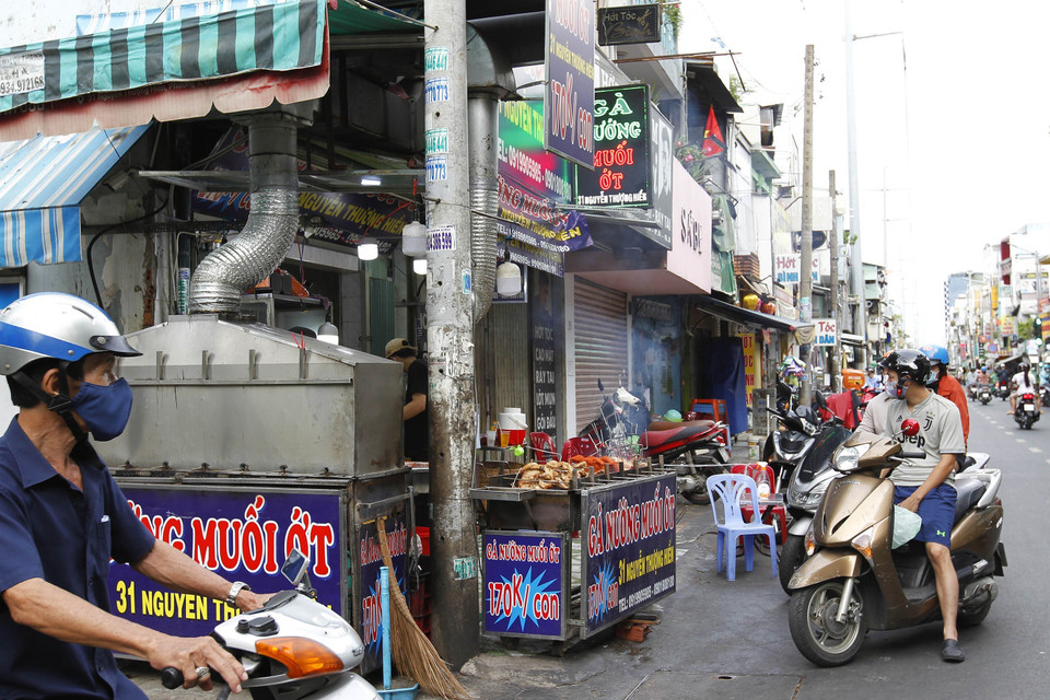Hàng bán mang đi đảm bảo giữa khoảng cách trên đường Nguyễn Thượng Hiền, Quận 3 trước giờ thực hiện giãn cách. (Ảnh: Thanh Vũ/TTXVN)