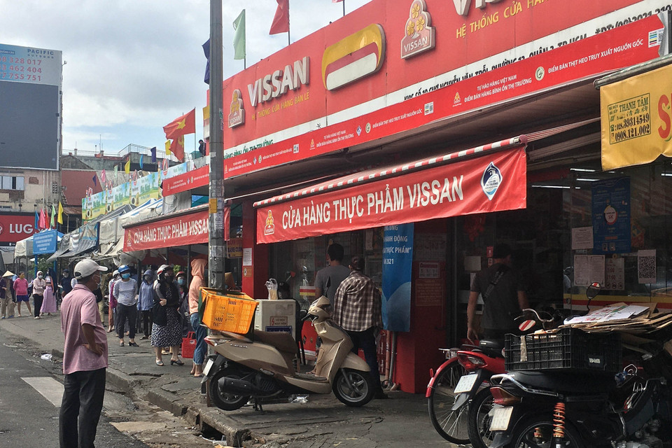 Đông đảo người tiêu dùng xếp hàng chờ đến lươt mua sắm tại cửa hàng Vissan trên đường Lê Văn Sỹ, Quận 3 trước giờ thực hiện giãn cách theo Chỉ thị 16 của Thủ tướng Chính phủ. (Ảnh: Thanh Vũ/TTXVN)