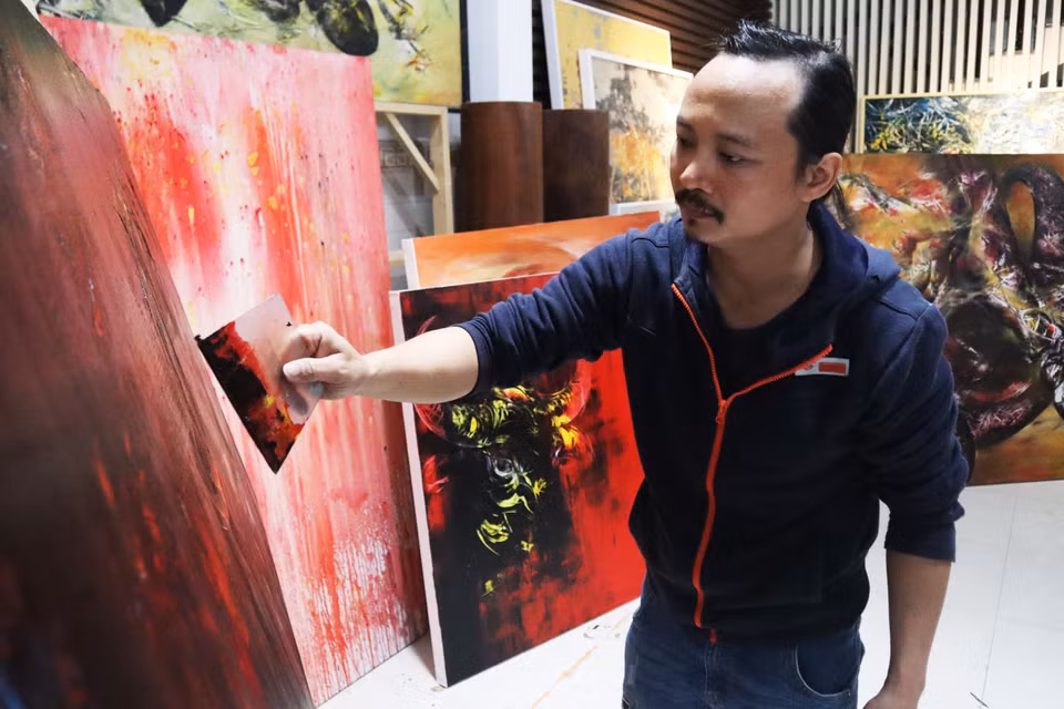 Họa sĩ Ngô Thanh Hùng sáng tác tranh tại nhà. (Ảnh: Văn Dũng/TTXVN)