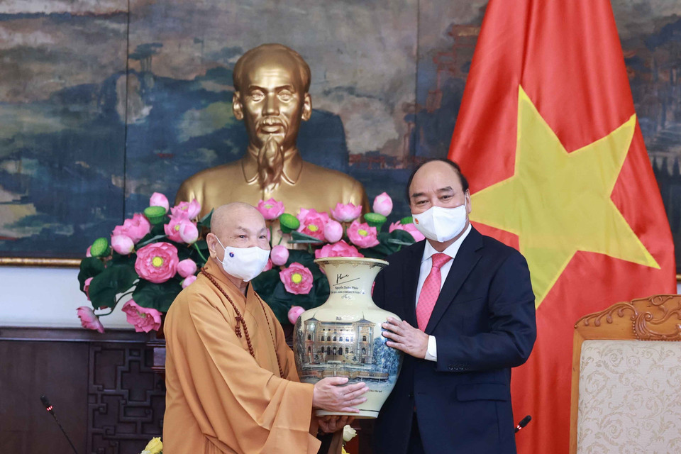 Chủ tịch nước Nguyễn Xuân Phúc tặng quà lưu niệm cho Hội đồng Trị sự Trung ương Giáo hội Phật giáo Việt Nam. (Ảnh: Thống Nhất/TTXVN)