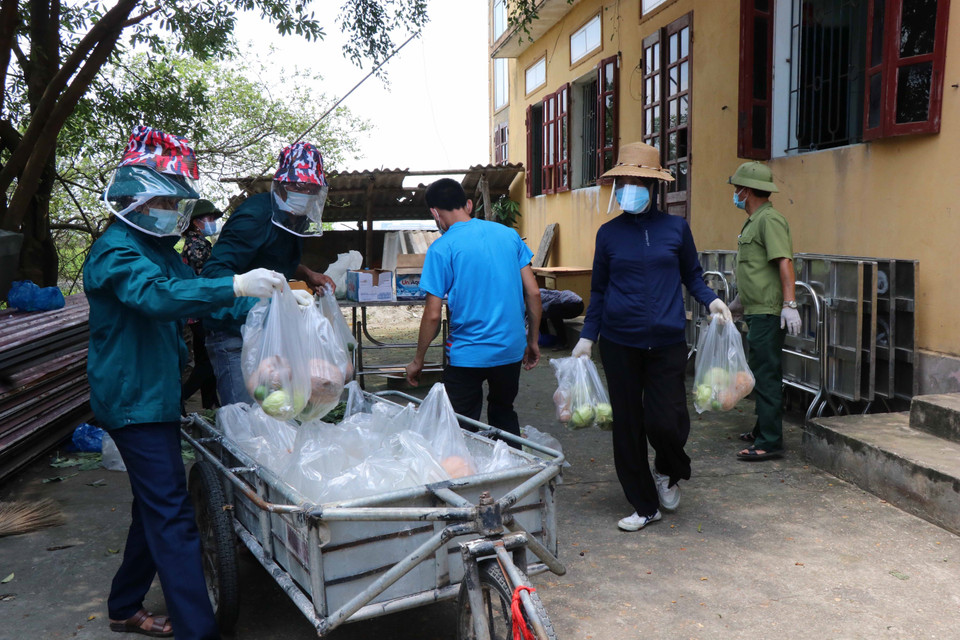 Các tình nguyện viên chuyển thực phẩm lên xe để đi phân phát cho các hộ dân tại xã Mão Điền. (Ảnh: Thanh Thương/TTXVN)
