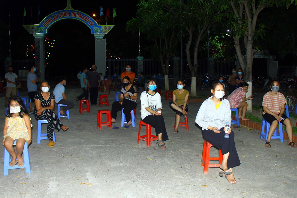 Người dân xã Hưng Đông, thành phố Vinh (Nghệ An) thực hiện nghiêm việc giãn cách khi chờ lấy mẫu xét nghiệm. (Ảnh: Tá Chuyên/TTXVN)