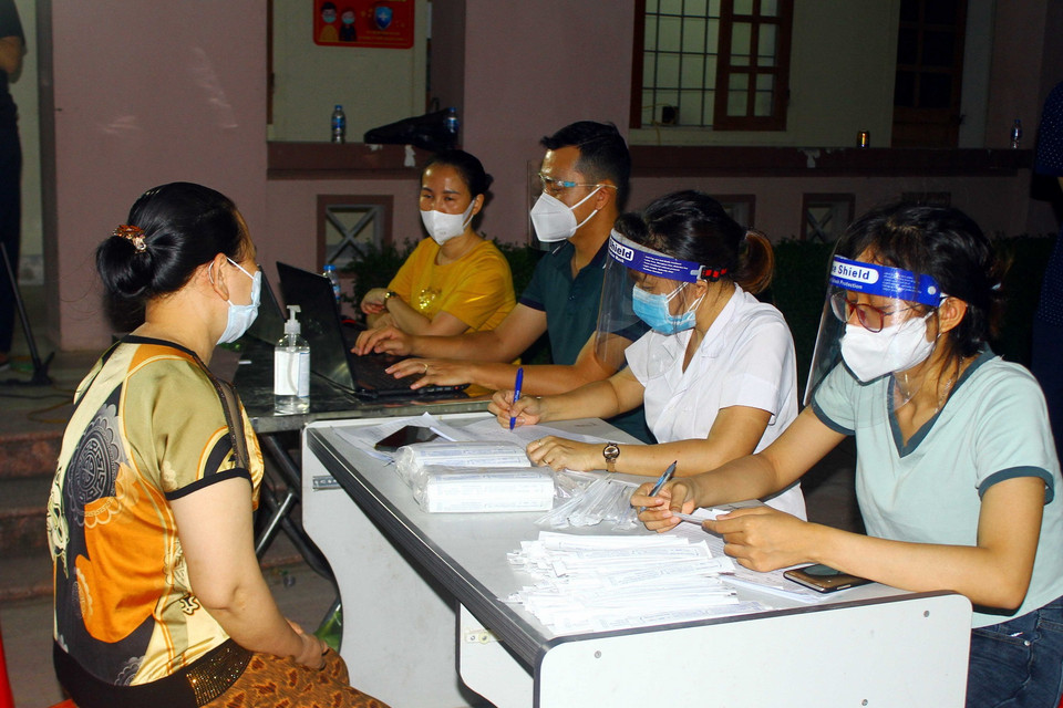  Người dân xã Hưng Đông, thành phố Vinh (Nghệ An) khai báo thông tin trước khi lấy mẫu xét nghiệm COVID-19 vào tối ngày 20/6. (Ảnh: Tá Chuyên/TTXVN)