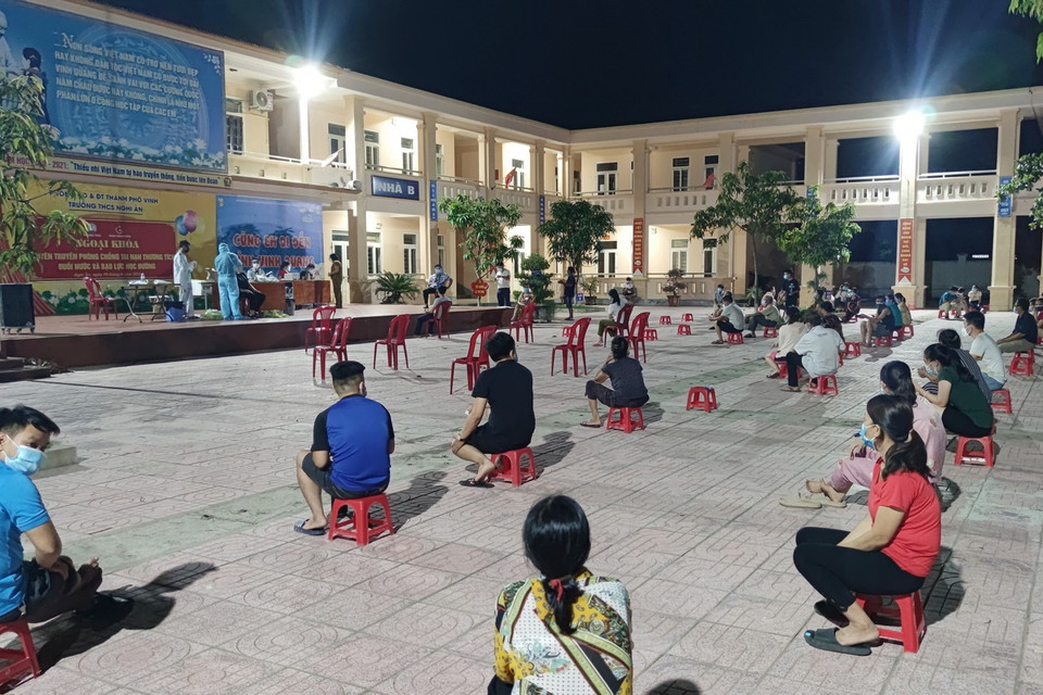 Người dân đến lấy mẫu xét nghiệm được lực lượng chức năng hướng dẫn giữ khoảng cách an toàn, tuân thủ các quy định phòng dịch COVID-19. (Ảnh: Văn Tý/TTXVN)