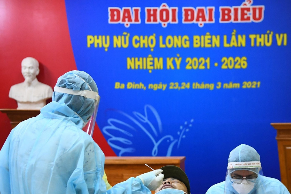 Lấy mẫu xét nghiệm cho các tiểu thương khu hải sản chợ Long Biên. (Ảnh: Thành Đạt/TTXVN)