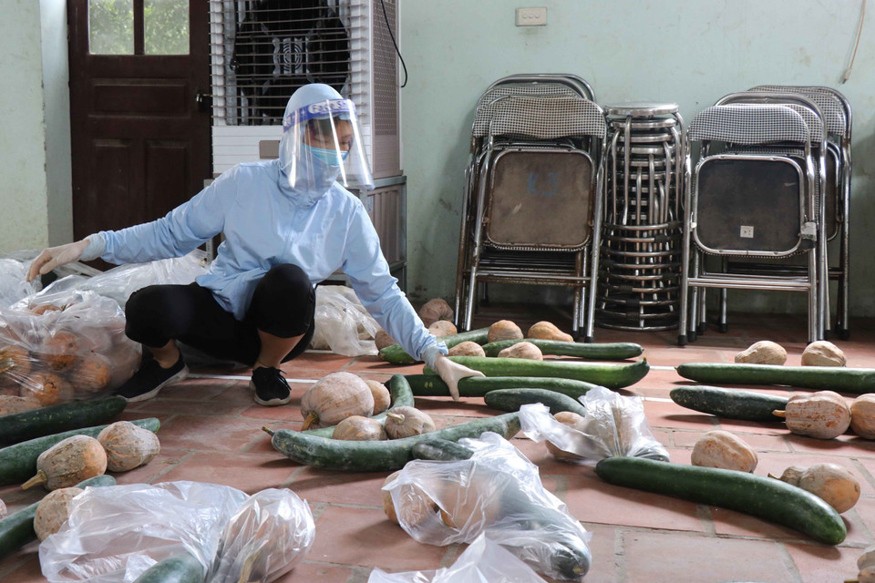 Các tình nguyện viên chia thực phẩm chuẩn bị cho người dân tại xã Mão Điền. (Ảnh: Thanh Thương/TTXVN)