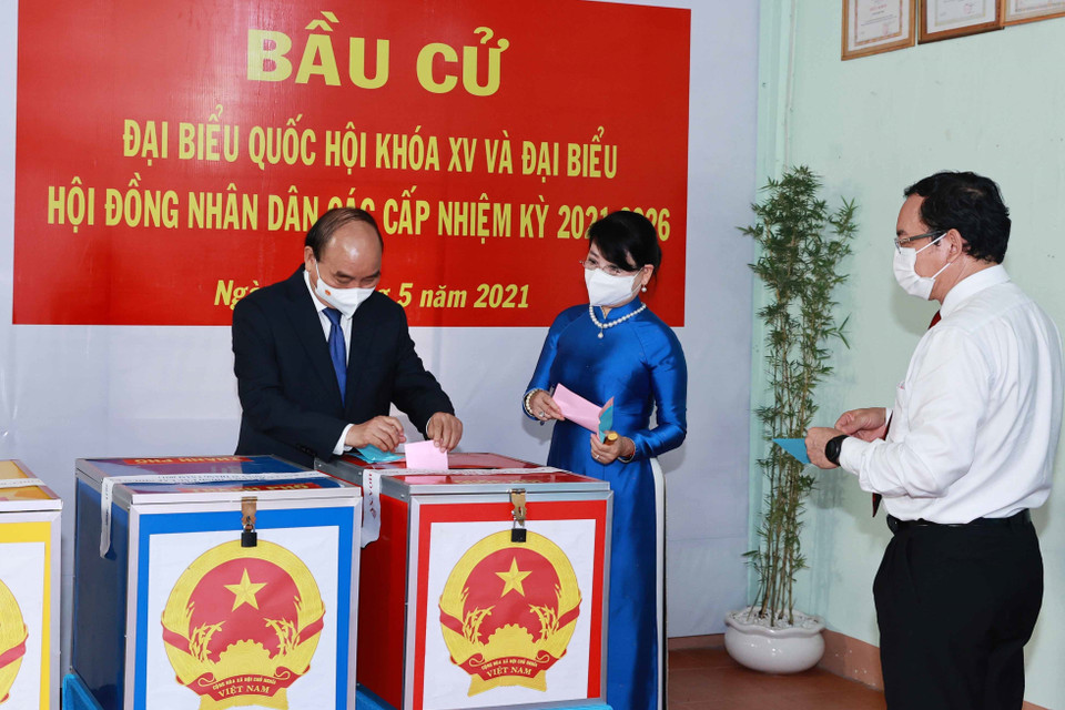 Chủ tịch nước Nguyễn Xuân Phúc cùng Phu nhân và Bí thư Thành uỷ Thành phố Hồ Chí Minh Nguyễn Văn Nên cùng các cử tri bỏ phiếu bầu đại biểu Quốc hội khóa XV và Hội đồng nhân dân các cấp nhiệm kỳ 2021-2026. (Ảnh: Thống Nhất/TTXVN)