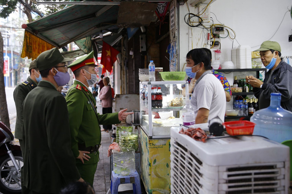  Lực lượng chức năng Công an phường Hàng Mã ra quân đề nghị các hộ kinh doanh đóng cửa quán ăn đường phố, trà đá, càphê. (Ảnh: Doãn Tấn/TTXVN)