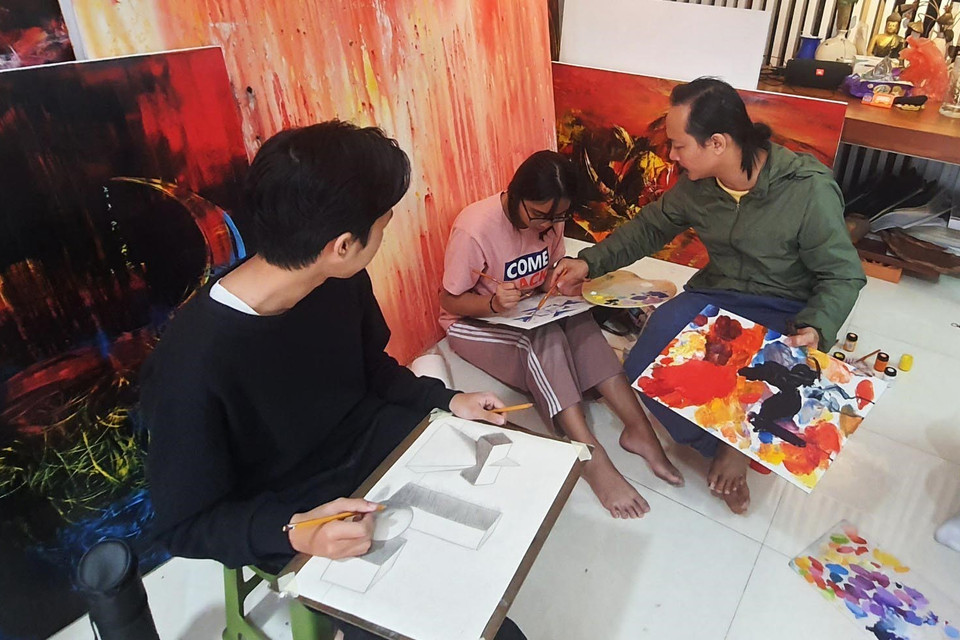 Họa sỹ Ngô Thanh Hùng dạy học sinh vẽ tại nhà. (Ảnh: Văn Dũng/TTXVN)