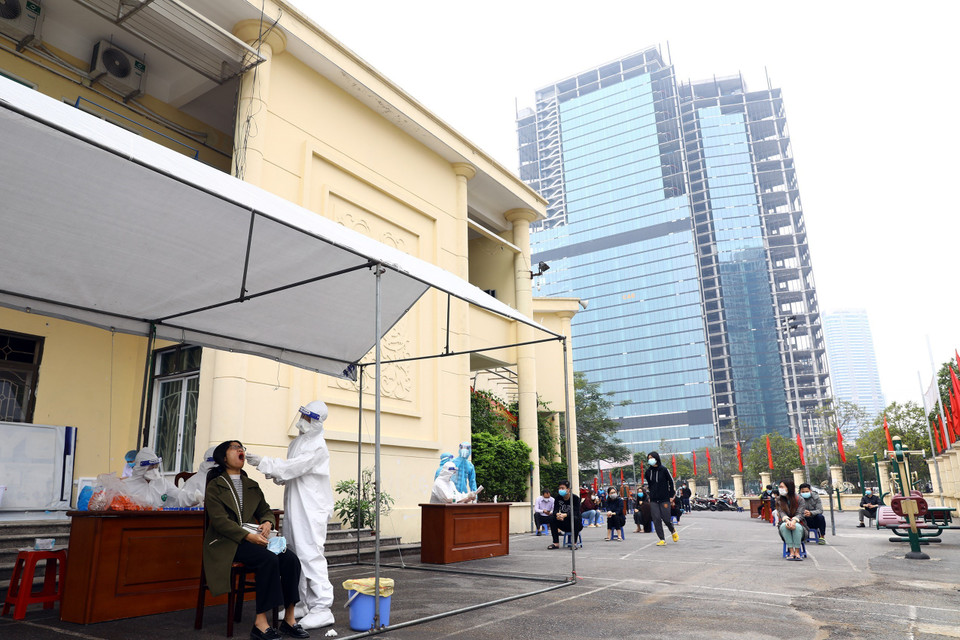 Lẫy mẫu xét nghiệm cho người dân tại khu vực quận Cầu Giấy tại điểm nhà văn hóa phường Yên Hòa. (Ảnh: Huy Hùng/TTXVN)