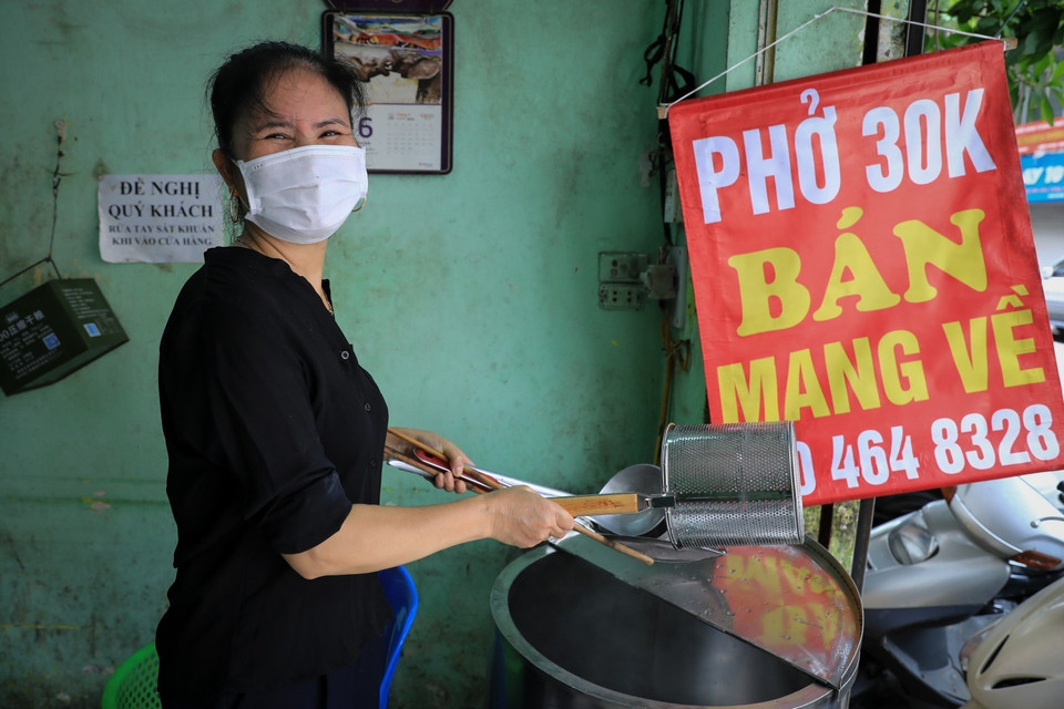 Chị Nguyễn Thị Thanh, chủ cửa hàng phở 59 Quán Thánh vui vẻ chia sẻ niềm vui khi được mở cửa trở lại. (Ảnh: Thành Đạt/TTXVN)