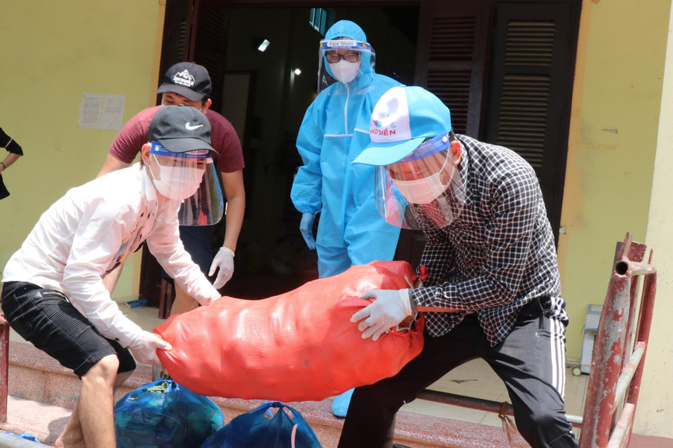 Đội ngũ tình nguyện viên chuyển thực phẩm từ các nhà tài trợ mang đến phát cho người dân tại xã Mão Điền.(Ảnh: Thanh Thương/TTXVN)