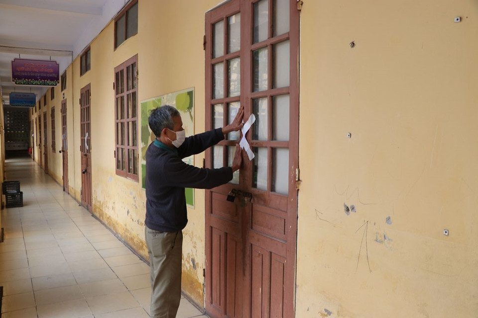 Tiến hành dán niêm phong phòng học tại Trường Tiểu học Võ Thị Sáu, phường Trần Phú, thành phố Hải Dương trong sáng 29/1. (Ảnh: Mạnh Minh/TTXVN)