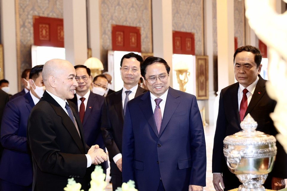 Quốc vương Campuchia Norodom Sihamoni giới thiệu với Thủ tướng Phạm Minh Chính một số tặng phẩm của Hoàng cung. (Ảnh: Dương Giang/TTXVN)