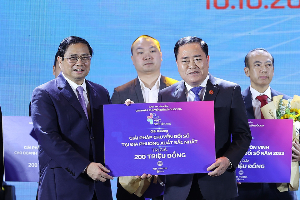 Thủ tướng Phạm Minh Chính và Bộ trưởng Bộ Thông tin và Truyền thông Nguyễn Mạnh Hùng trao giải Cuộc thi Tìm kiếm giải pháp Chuyển đổi số quốc gia cho đại diện bộ, ngành, địa phương, doanh nghiệp và cộng đồng. (Ảnh: Dương Giang/TTXVN)