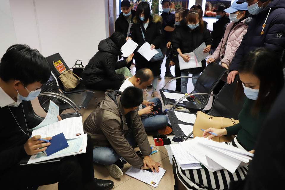 Cán bộ Đại sứ quán Việt Nam kiểm tra, cấp thẻ thông hành cho kiều bào. (Ảnh: Mạnh Hùng/TTXVN)