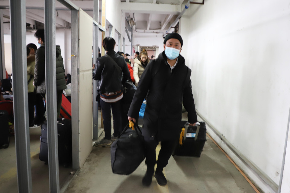 Kiều bào di chuyển xuống xe buýt để ra sân bay thủ đô Bucharest, Romania. (Ảnh: Mạnh Hùng/TTXVN)