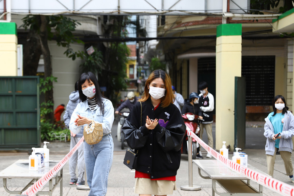 Thực hiện đo thân nhiệt và khử khuẩn trước khi vào trường. (Ảnh: Hoài Nam/Vietnam+)