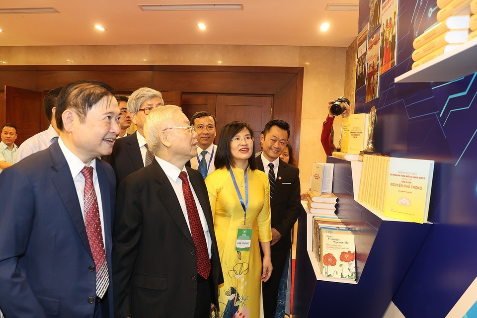 Tổng Bí thư Nguyễn Phú Trọng và các đại biểu tham quan gian trưng bày sách tại lễ kỷ niệm. (Ảnh: Trí Dũng/TTXVN)