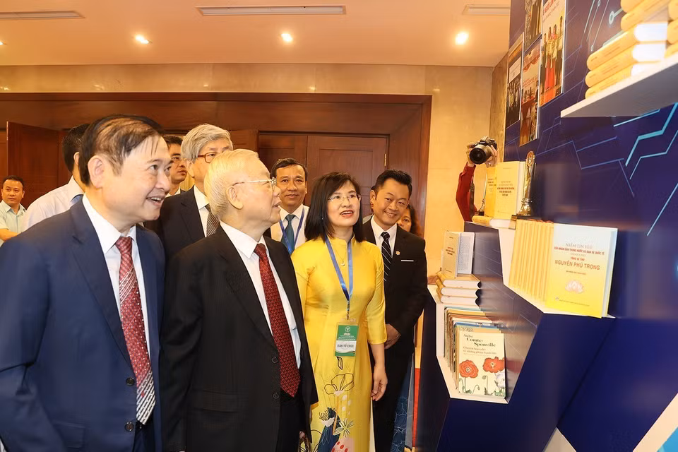 Tổng Bí thư Nguyễn Phú Trọng và các đại biểu tham quan gian trưng bày sách tại lễ kỷ niệm. (Ảnh: Trí Dũng/TTXVN)