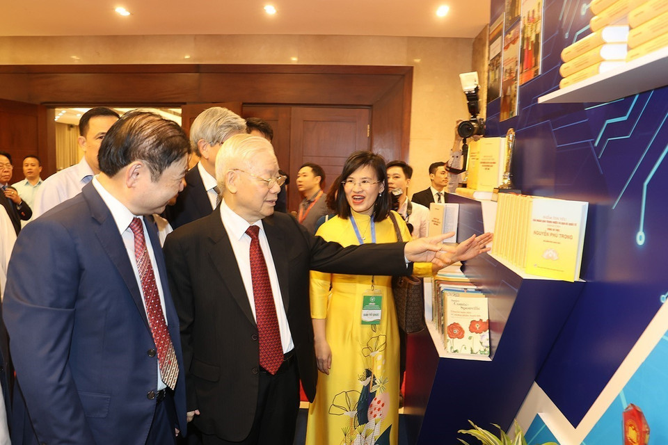 Tổng Bí thư Nguyễn Phú Trọng tham quan gian trưng bày sách tại lễ kỷ niệm. (Ảnh: Trí Dũng/TTXVN)