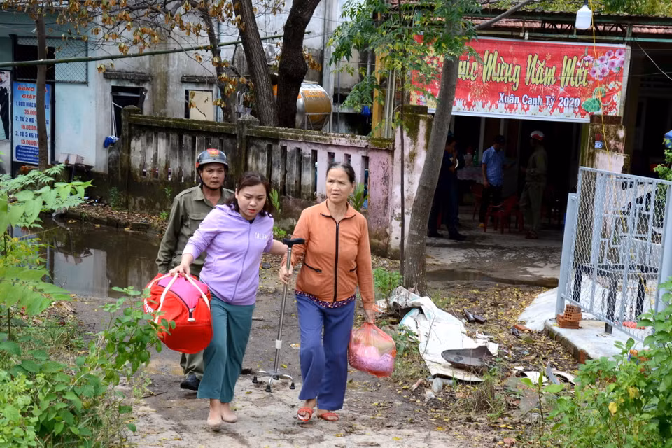 Bà Hồ Thị Cẩm Nhung, Chủ tịch UBND phường Hòa Xuân, quận Cẩm Lệ, thành phố Đà Nẵng (bên trái) hỗ trợ người dân di tản tránh bão số 9. (Ảnh: Quốc Dũng/TTXVN)