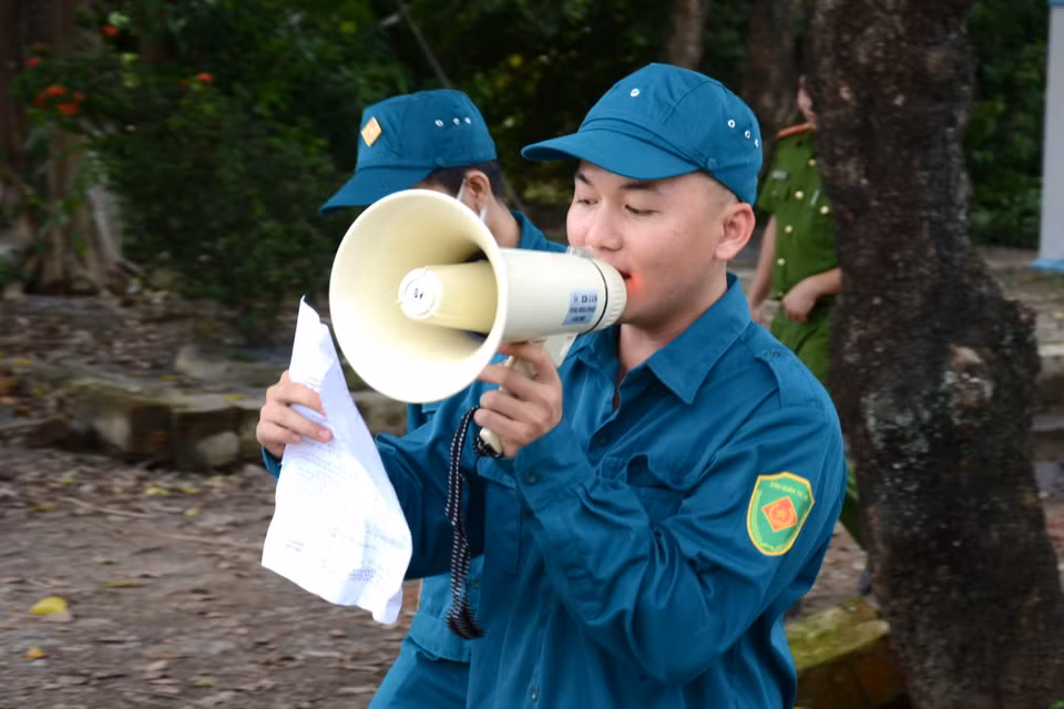 Lực lượng chức năng kêu gọi, vận động người dân trong khu vực nguy hiểm nhanh chóng di dời tránh bão số 9. (Ảnh: Quốc Dũng/TTXVN)