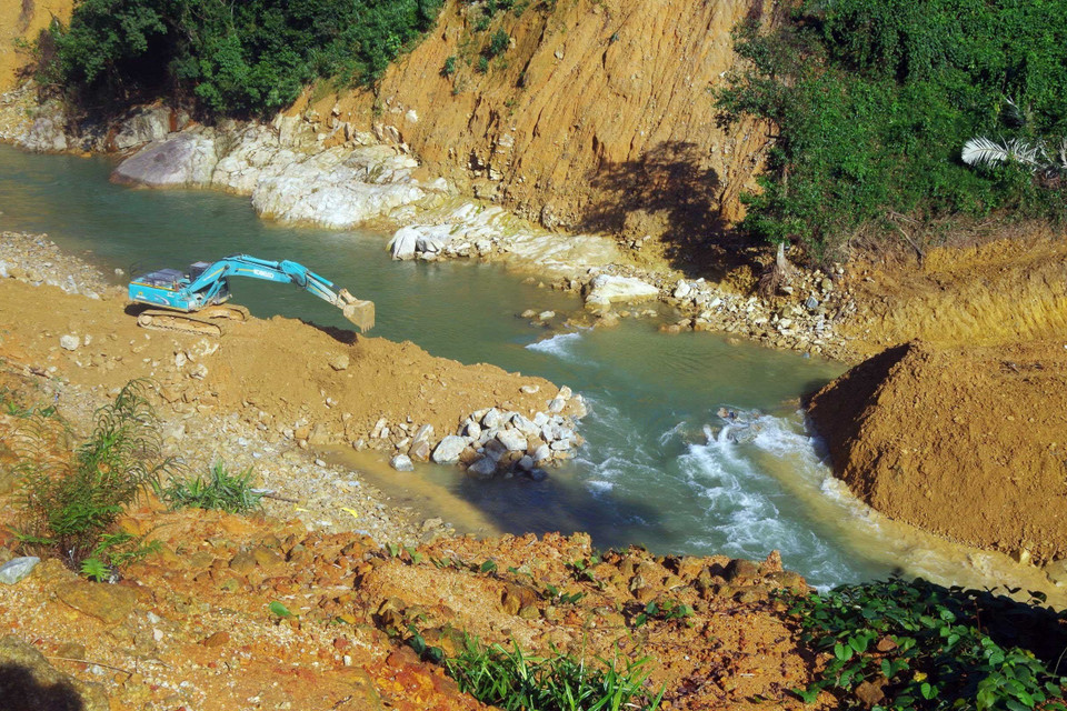 Các lực lượng cùng với phương tiện máy móc tích cực hoàn thành việc nắn dòng suối Rào Trăng trong ngày 21/11. (Ảnh: TTXVN phát)