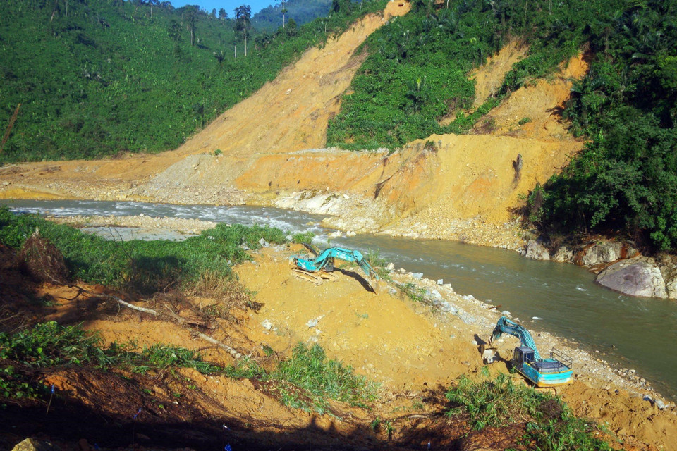 Các lực lượng cùng với phương tiện máy móc tích cực hoàn thành việc nắn dòng suối Rào Trăng trong ngày 21/11. (Ảnh: TTXVN phát)