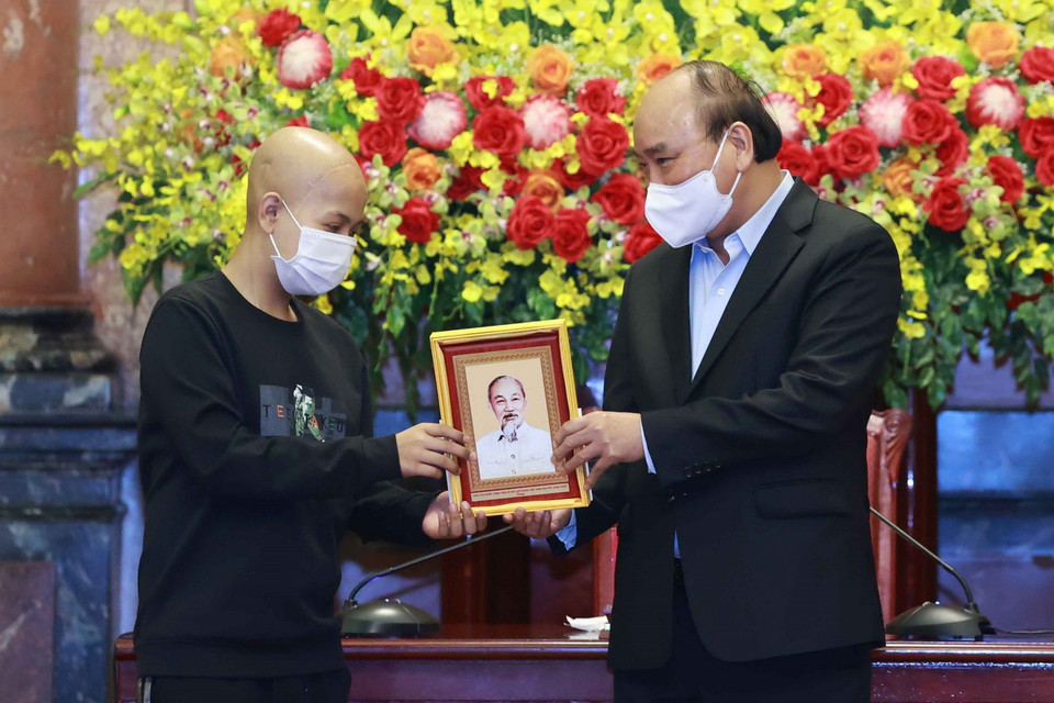 Chủ tịch nước Nguyễn Xuân Phúc tặng chân dung Chủ tịch Hồ Chí Minh cho các học sinh. (Ảnh: Thống Nhất/TTXVN)