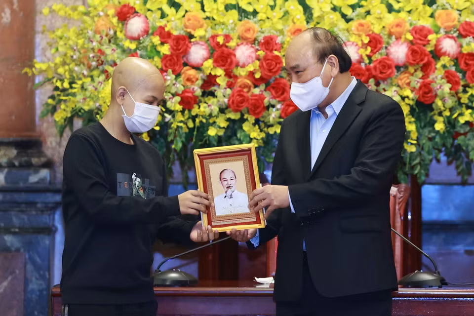 Chủ tịch nước Nguyễn Xuân Phúc tặng chân dung Chủ tịch Hồ Chí Minh cho các học sinh. (Ảnh: Thống Nhất/TTXVN)