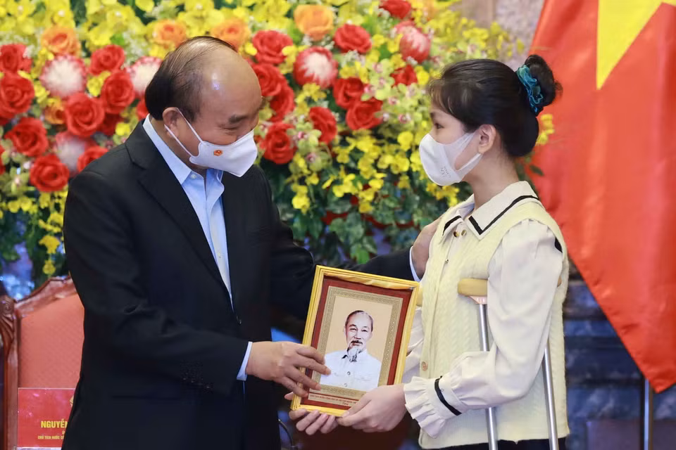 Chủ tịch nước Nguyễn Xuân Phúc tặng chân dung Chủ tịch Hồ Chí Minh cho học sinh xuất sắc trong cuộc thi “Vì một Việt Nam tất thắng.” (Ảnh: Thống Nhất/TTXVN)