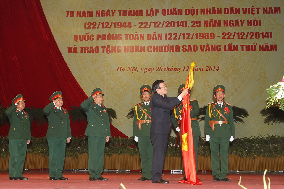 Chủ tịch nước Trương Tấn Sang gắn Huân chương Sao Vàng lên lá cờ truyền thống của Quân đội nhân dân Việt Nam. (Ảnh: Trí Dũng/TTXVN)