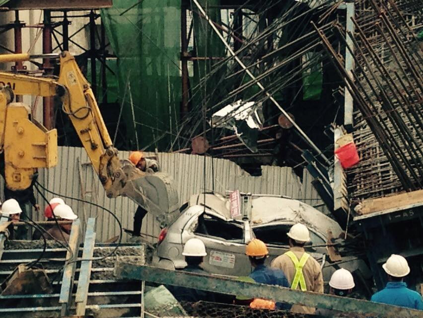 Dùng một xe xúc móc kéo ngược taxi ra khỏi đống vật liệu (Ảnh: Sơn Bách-Võ Phương/Vietnam+)