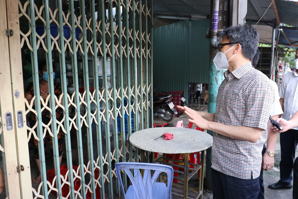  Phó Thủ tướng Vũ Đức Đam thăm hỏi, động viên, một nhà dân sống tại phường Thuận Giao, thành phố Thuận An, tỉnh Bình Dương, trong thời gian bị "khóa chặt" để phòng, chống dịch. (Ảnh: TTXVN)