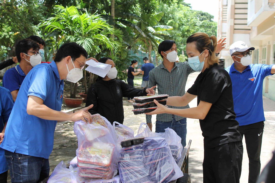 Lực lượng thanh niên tình nguyện chuẩn bị các suất cơm cho người dân tại Nhà nghỉ Công đoàn Thanh Đa.(Ảnh: Thanh Vũ/TTXVN)
