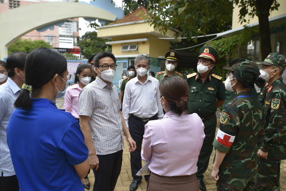 Phó Thủ tướng Vũ Đức Đam động viên lực lượng chức năng tham gia chống dịch trên địa bàn Quận 6.(Ảnh: TTXVN phát)