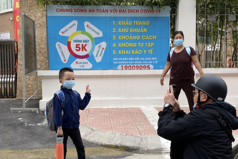 Việc được đi học trực tiếp, được tiếp xúc với bạn bè, thầy cô khiến cha mẹ và học sinh đều hào hứng. Hình ảnh ghi nhận tại trường Tiểu học Hoàng Mai, vị phụ huynh này ghi lại khoảnh khắc con trai lần đầu tiên bước chân tới trường tiểu học. (Ảnh: PV/Vietnam+)