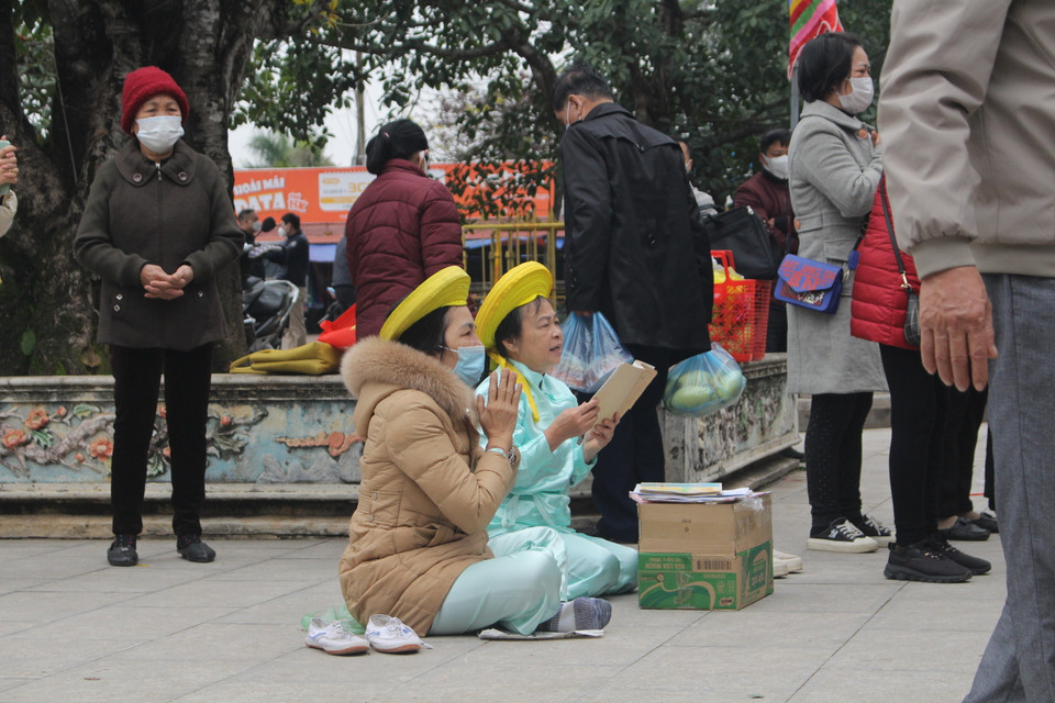 Tuy nhiên vẫn còn một số cá nhân chủ quan, gỡ khẩu trang khi thực hành khấn lễ. (Ảnh: Minh Anh/Vietnam+)