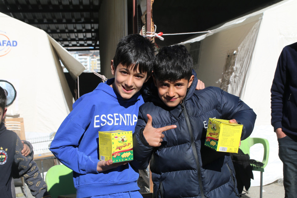 Hai em nhỏ vui mừng khi nhận được những phần quà lương khô của đội mới trao tặng. (Ảnh: Trường Dụy/TTXVN)