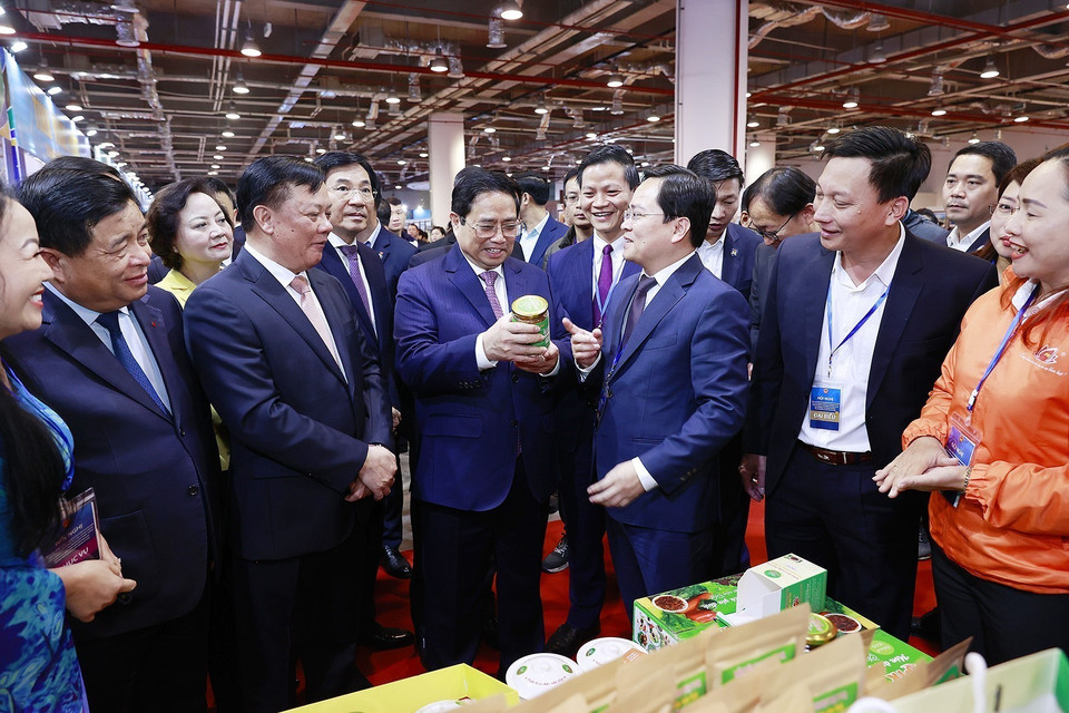 Thủ tướng Phạm Minh Chính xem trưng bày sản phẩm nông nghiệp, thủ công, mỹ nghệ của các tỉnh Đồng bằng sông Hồng. (Ảnh: Dương Giang/TTXVN)