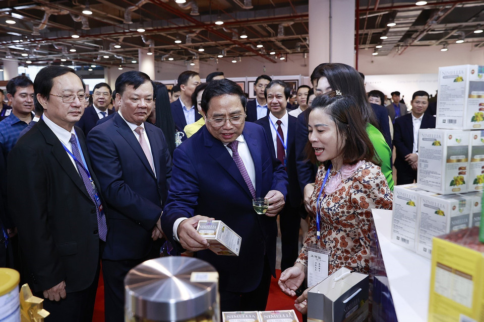 Thủ tướng Phạm Minh Chính xem trưng bày sản phẩm nông nghiệp, thủ công, mỹ nghệ của các tỉnh Đồng bằng sông Hồng. (Ảnh: Dương Giang/TTXVN)