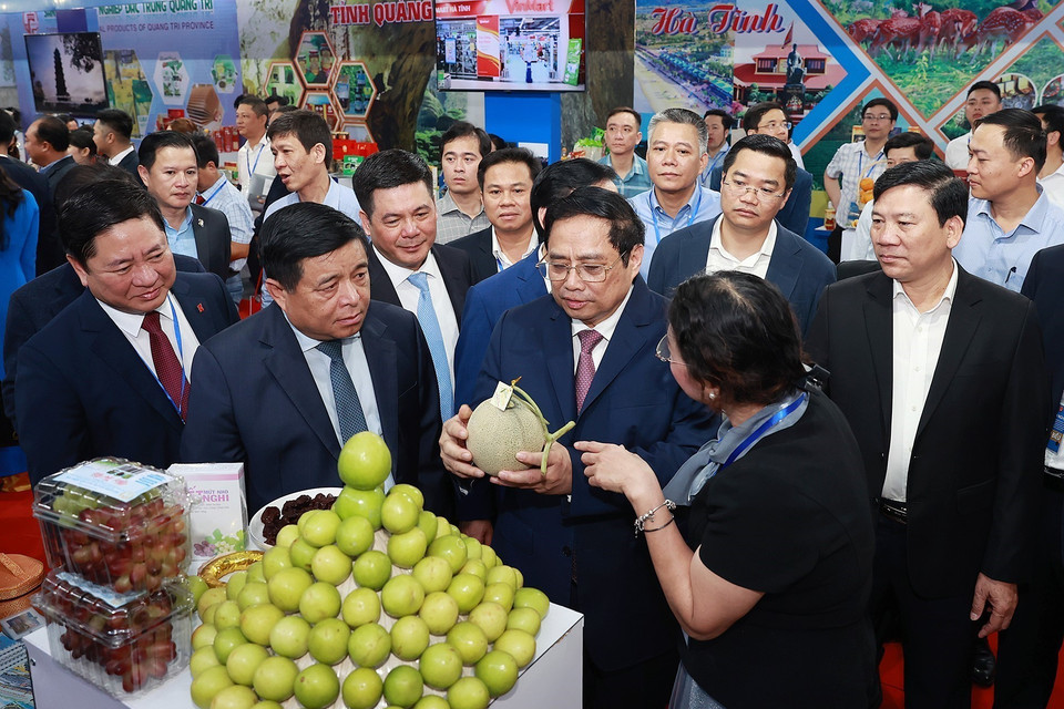 Thủ tướng Phạm Minh Chính nghe giới thiệu về sản phẩm của các tỉnh Bắc Trung Bộ và duyên hải Trung Bộ. (Ảnh: Dương Giang/TTXVN)