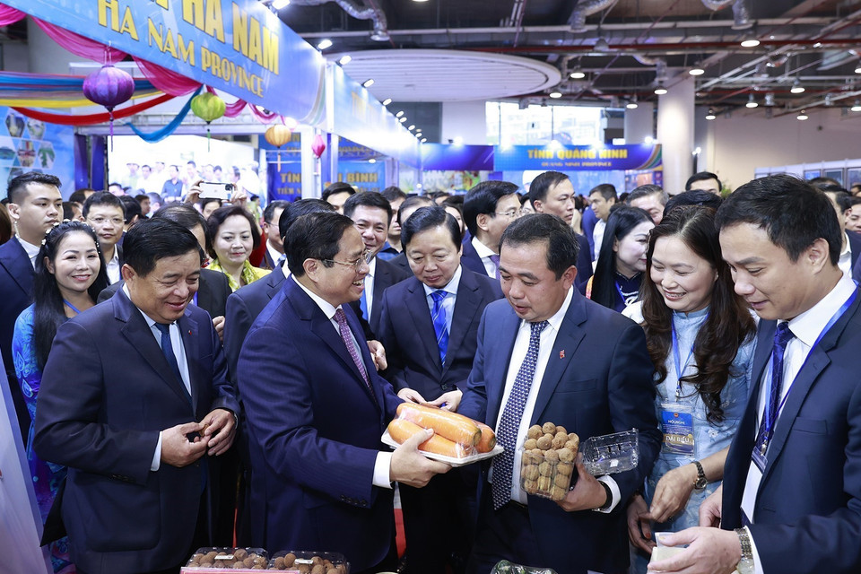 Thủ tướng Phạm Minh Chính xem trưng bày sản phẩm nông nghiệp. (Ảnh: Dương Giang/TTXVN)