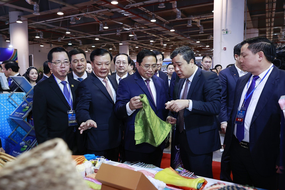 Thủ tướng Phạm Minh Chính xem trưng bày sản phẩm thủ công, mỹ nghệ của các làng nghề ở tỉnh Đồng bằng sông Hồng. (Ảnh: Dương Giang/TTXVN)