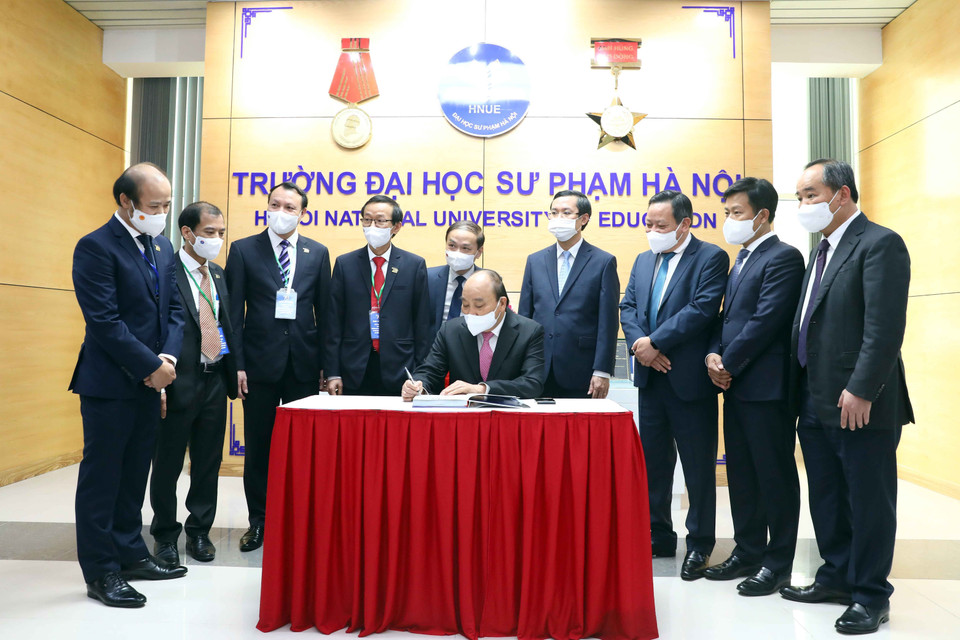 Chủ tịch nước Nguyễn Xuân Phúc viết cảm tưởng vào Sổ lưu niệm tại Phòng truyền thống của nhà trường. (Ảnh: Phạm Kiên/TTXVN)