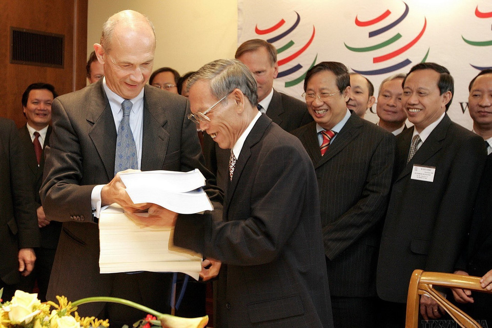 Ngày 7/11/2006, Bộ trưởng Thương mại Trương Đình Tuyển và Tổng giám đốc Tổ chức Thương mại Thế giới (WTO) Pascal Lamy ký Nghị định thư gia nhập WTO của Việt Nam. (Ảnh: AFP/TTXVN)