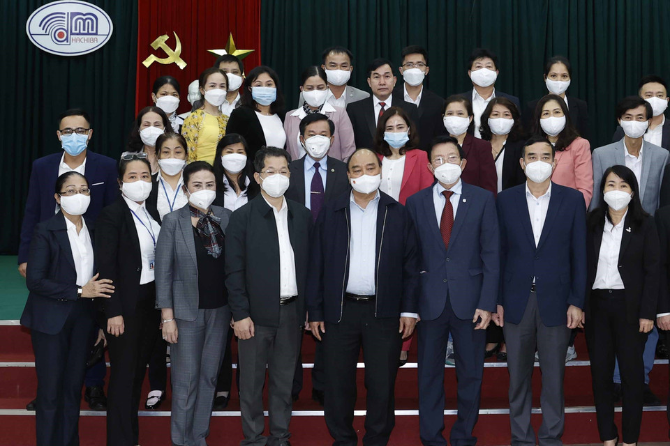 Chủ tịch nước Nguyễn Xuân Phúc chụp ảnh lưu niệm với lãnh đạo, người lao động Công ty cổ phần dệt may 29/3. (Ảnh: Thống Nhất/TTXVN)