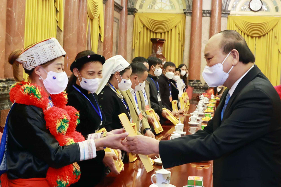 Chủ tịch nước Nguyễn Xuân Phúc tặng ảnh chân dung Chủ tịch Hồ Chí Minh cho các đại biểu người có uy tín, trưởng thôn tiêu biểu tỉnh Bắc Kạn. (Ảnh: Thống Nhất/TTXVN)