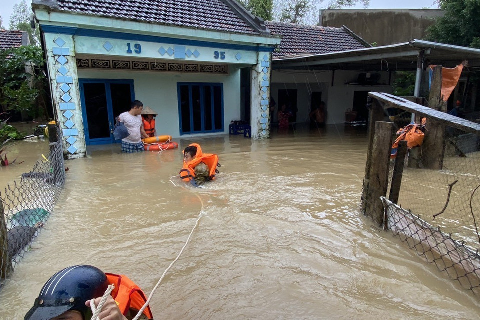 Người dân huyện Tuy Phước, tỉnh Bình Định được lực lượng chức năng hỗ trợ di dời đến nơi an toàn. (Ảnh: Tường Quân/TTXVN)